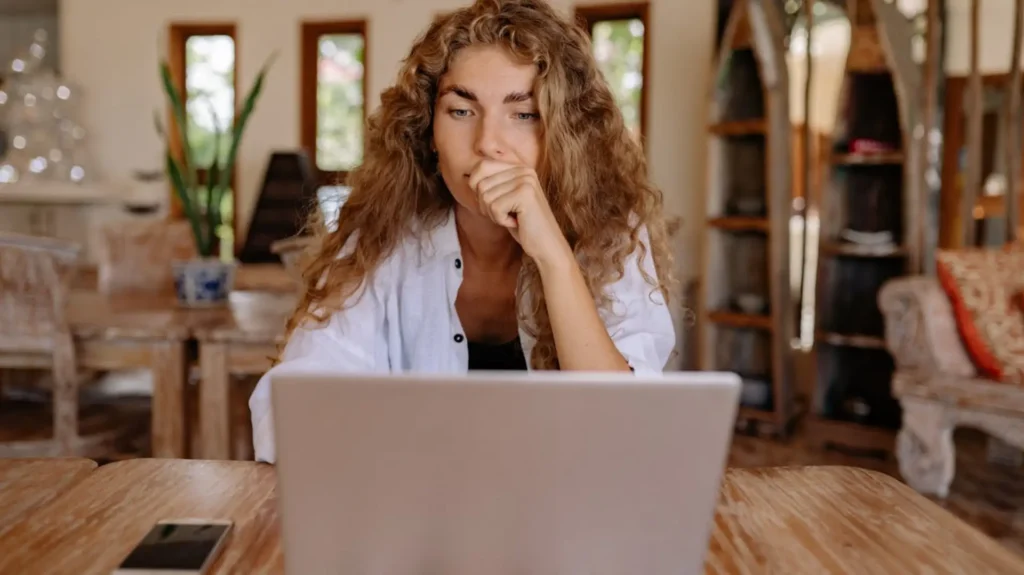Woman in front of laptop thinking