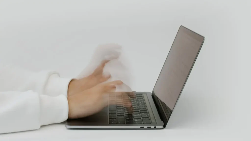 Blurred hands typing on laptop