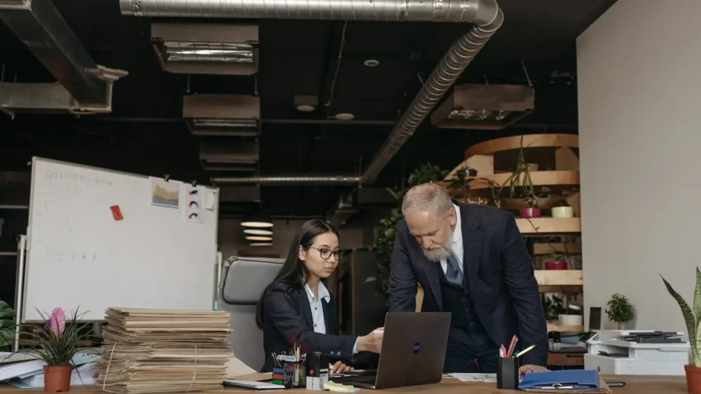 Professionals discussing digital contracts over laptop in office