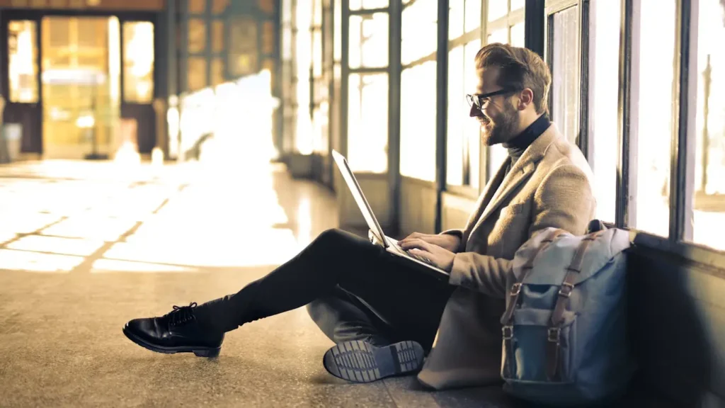 Man working on laptop at train station