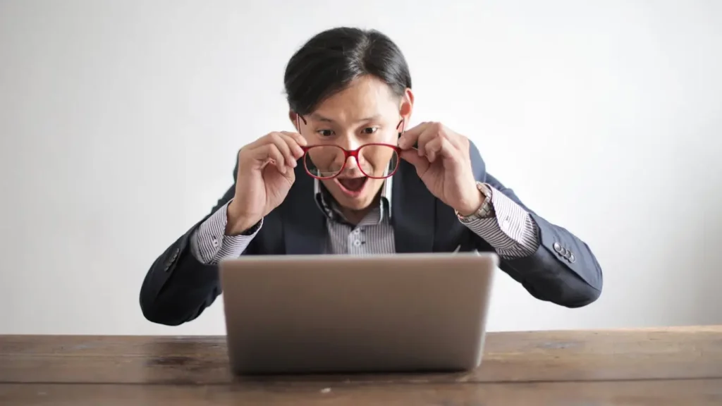 Surprised businessman looking at laptop